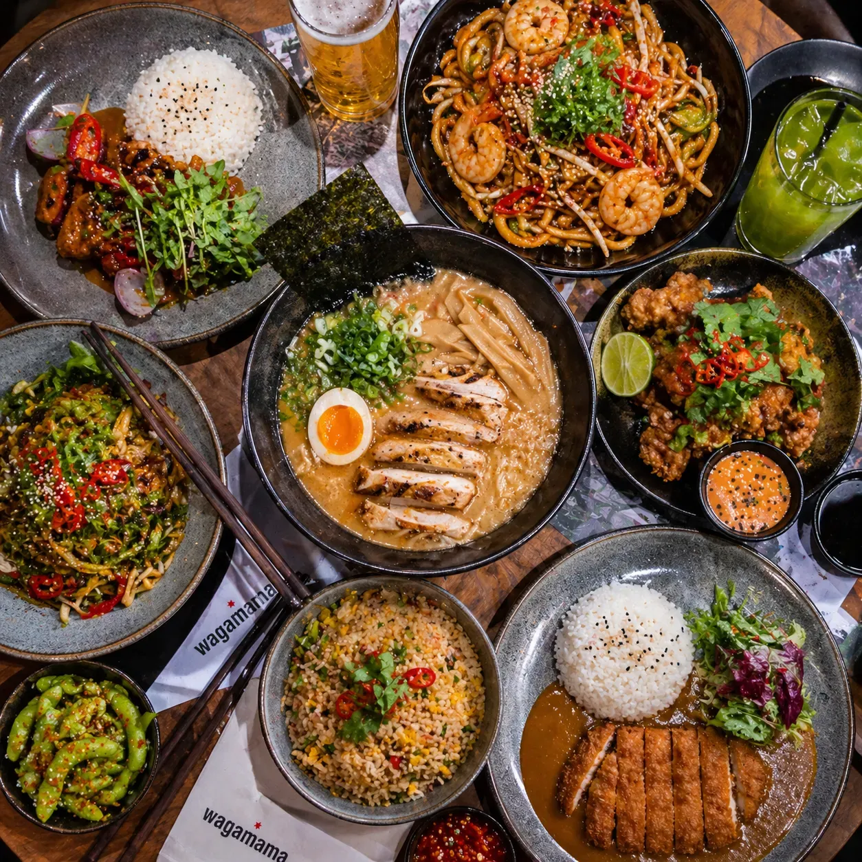 A table spread of Wagamama dishes, including ramen, katsu curry and fried rice